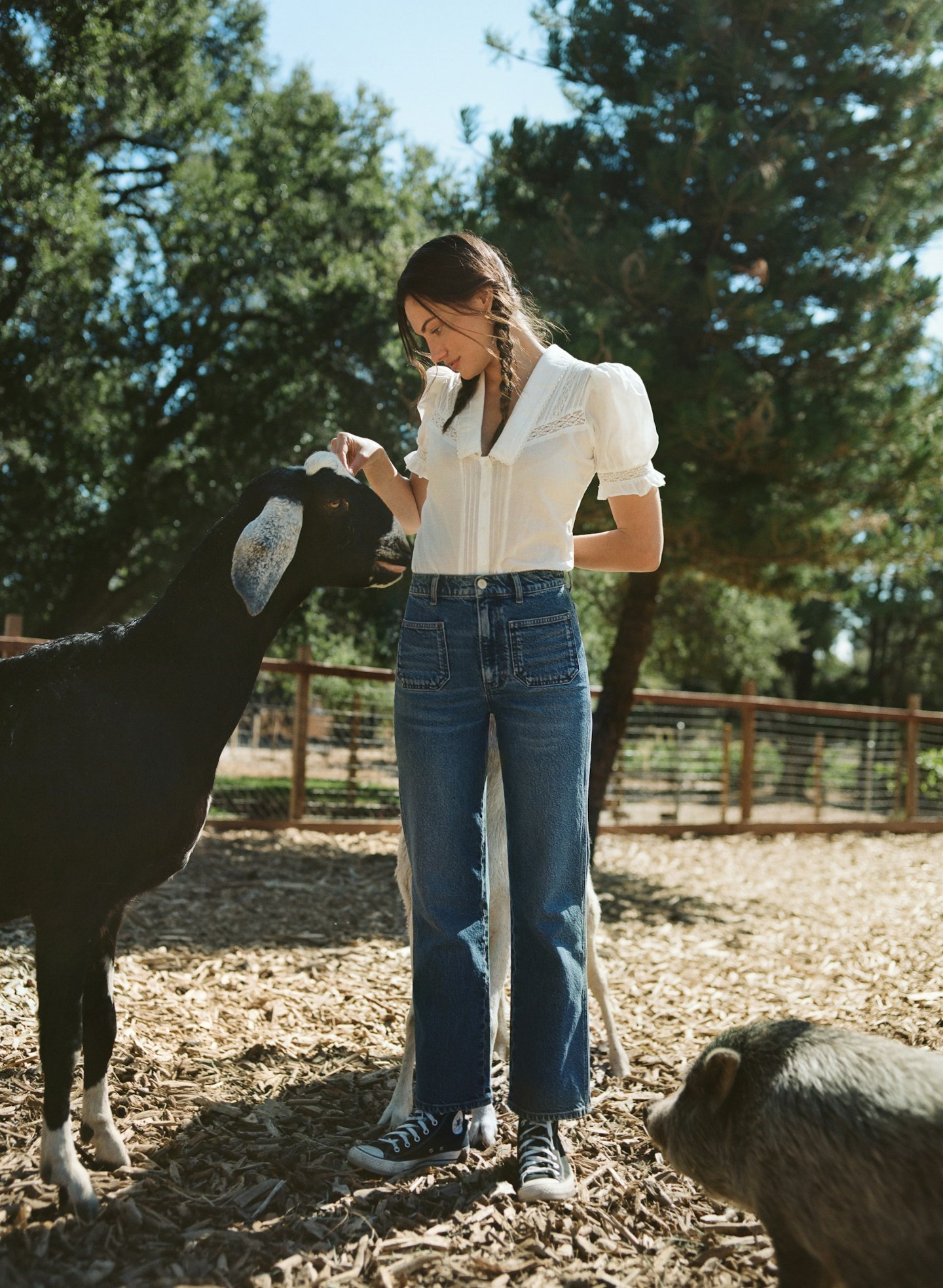 A model wearing a white blouse and jeans from Reformation's new collection with FibreTrace